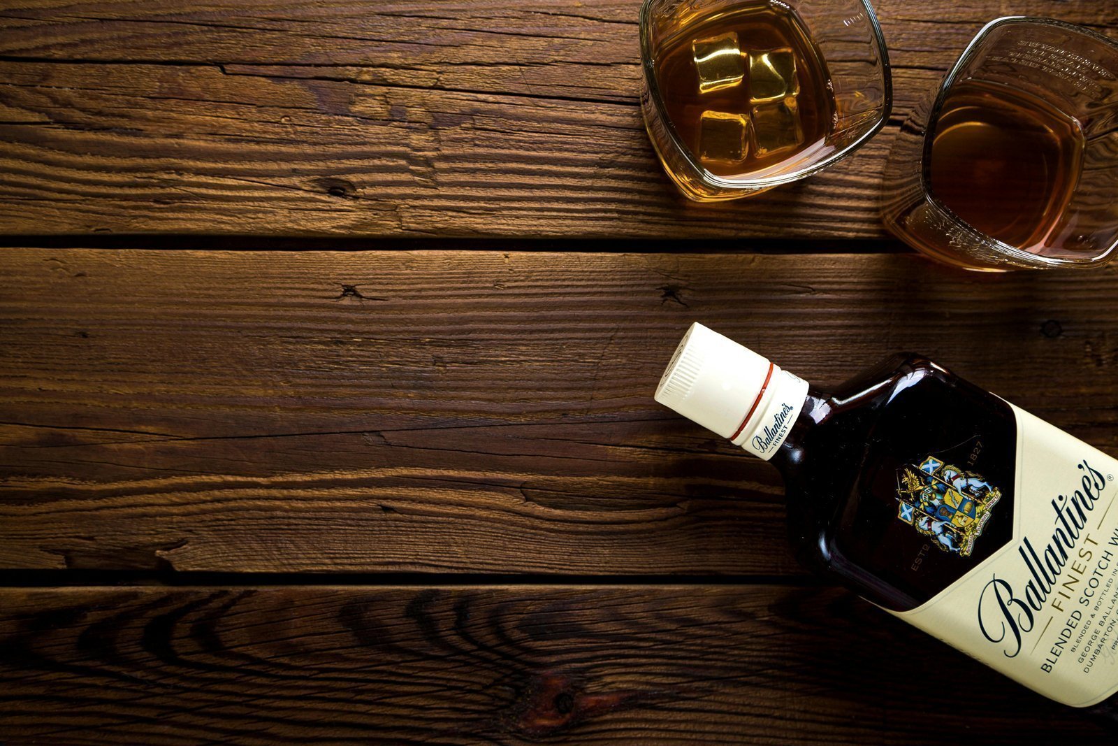 Eine Whiskeyflasche liegt auf einem Holztisch. 