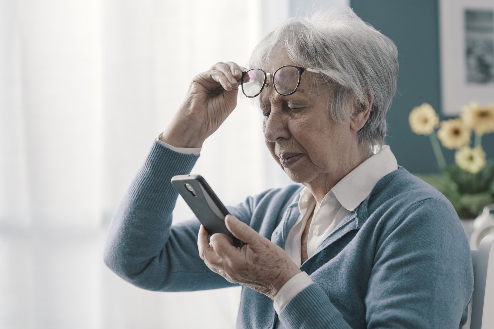 Eine Seniorin liest am Handy. 