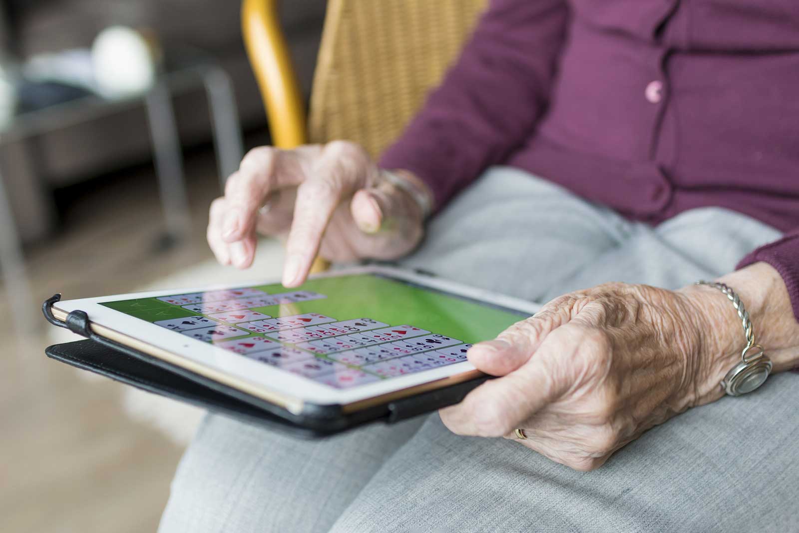 Eine Seniorin an einem technischen Gerät, das ihr auch in hohem Alter eine gute Lebensqualität ermöglicht.